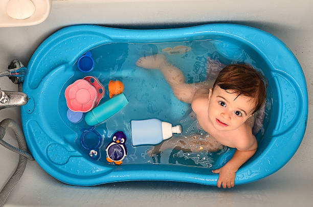 a baby covered in soap during bath time - bath toy imagens e fotografias de stock