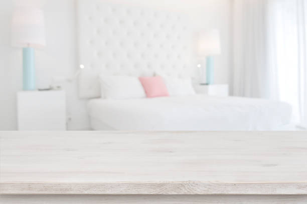tablero de mesa de madera frente al fondo interior del dormitorio borroso - hotel room bedding domestic room hotel suite fotografías e imágenes de stock