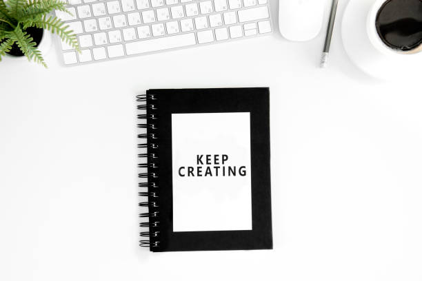 istock flat lay with keep crearing motivational quote on diary, computer mouse and keyboard isolated on white 689963934