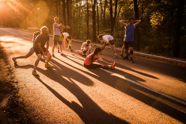 istock Group of runners warming up before the marathon on a road at sunset. 689964074