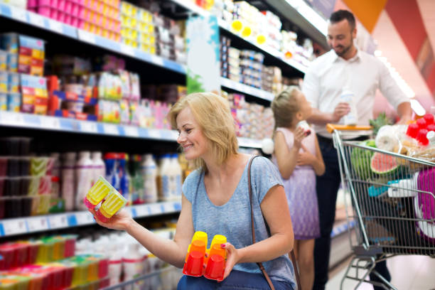 istock Smiling woman holding package with yogurt 689964606