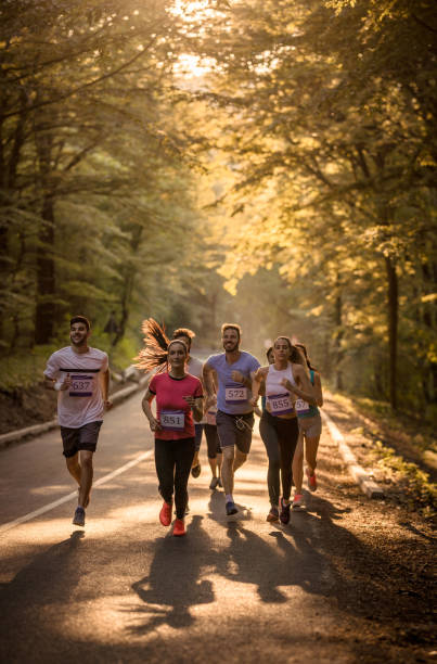 istock Large group of athletic people running a marathon through the forest. 689966904