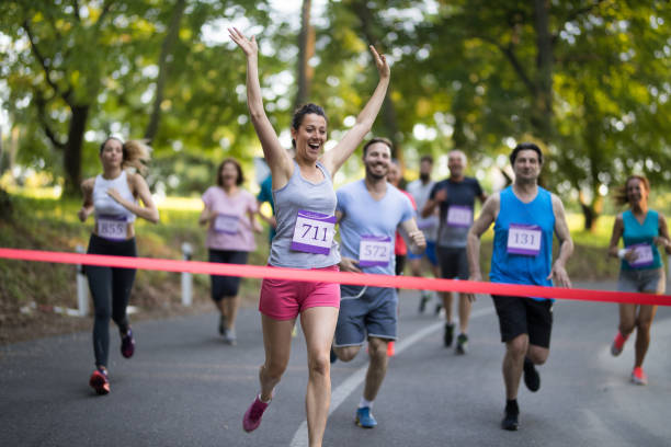 istock Successful marathon runner crossing the finish line with arms raised. 689967506