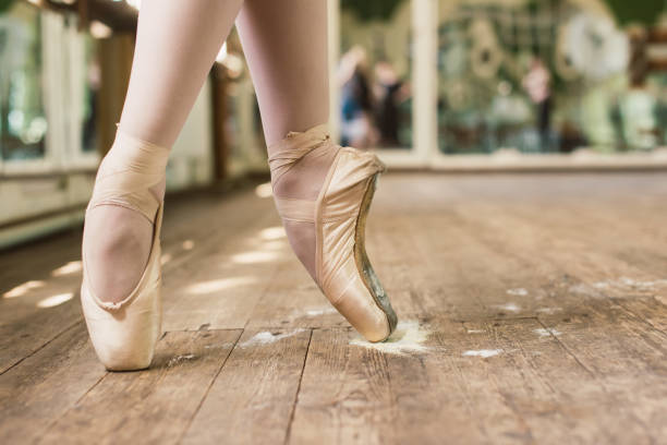 Pointe Shoes In Rosin Ballerina standing on toes. Closeup of dancing legs of ballerina wearing white pointes in the dancing hall. Pointe Shoes In Rosin rosin stock pictures, royalty-free photos & images