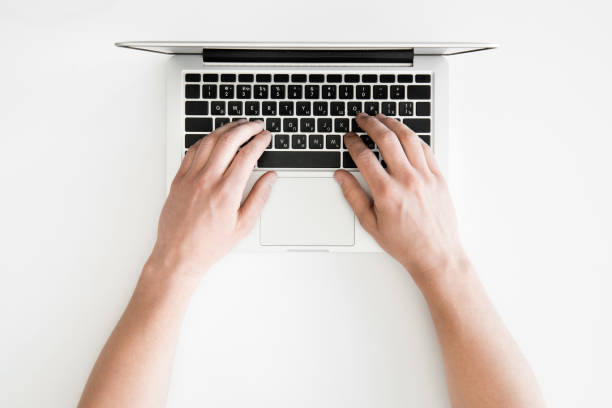 istock top view of human hands typing on laptop computer isolated on white, wireless communication concept 689968152