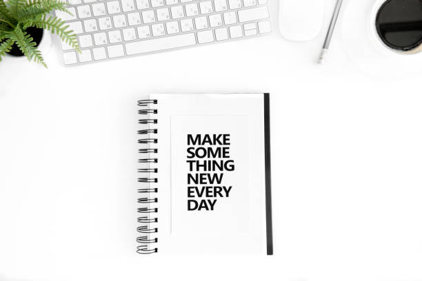istock top view of make something new every day motivational quote in diary, computer mouse and keyboard isolated on white 689968522