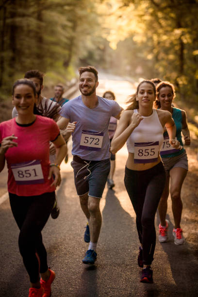 istock Group of runners taking part in a marathon race through the forest. 689968974