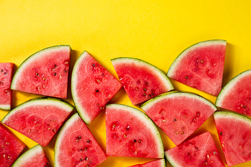 Beautiful pattern with fresh watermelon slices on yellow bright background. Top View.