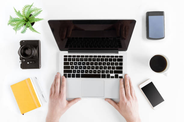 istock top view of hands holding laptop on modern workplace with coffee cup 689970924
