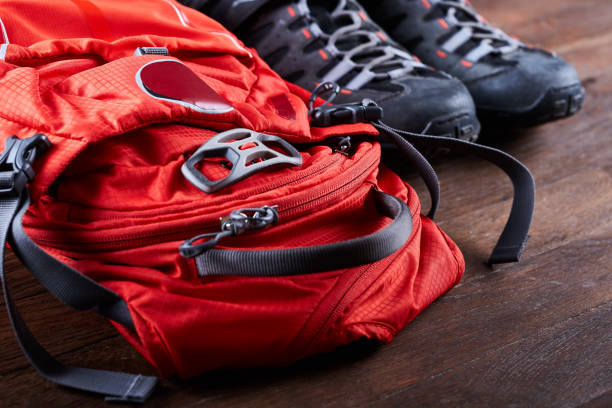 istock Hiking equipment: backpack and trekking boots on the wooden boards. 689974696