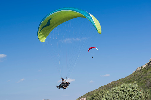 Colorful hang glider in sky over blue sea