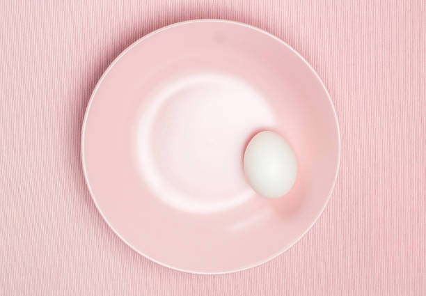 istock Top view of white egg on the pink plate 689975654