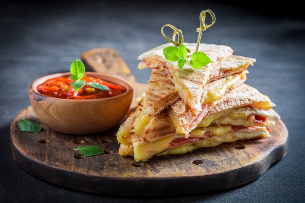 Spicy quesadilla made of tortilla with sauce and herbs stock photo