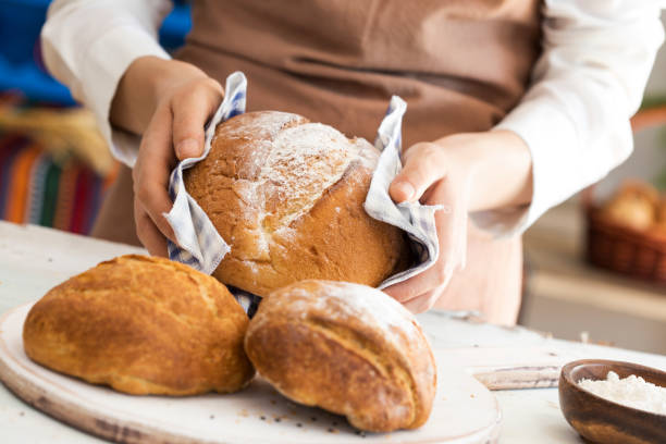istock Female hand holding hot freshly baked bread 689990406