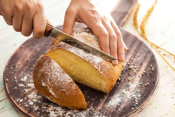 istock Female hands cutting freshly bread 689990536