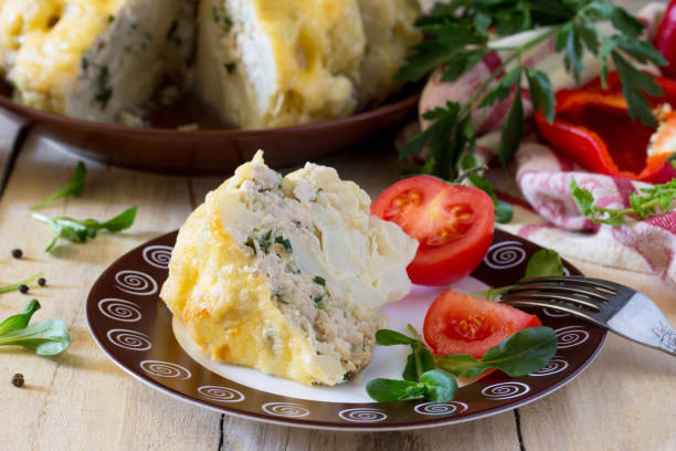 istock Cauliflower baked with cheese, stuffed with minced meat on a kitchen table in a rustic style. 689990740