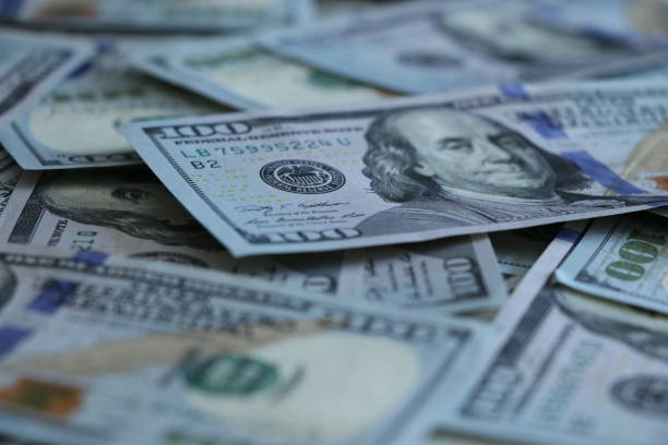istock Bunch of 100 dollar bills on black background. 689997156