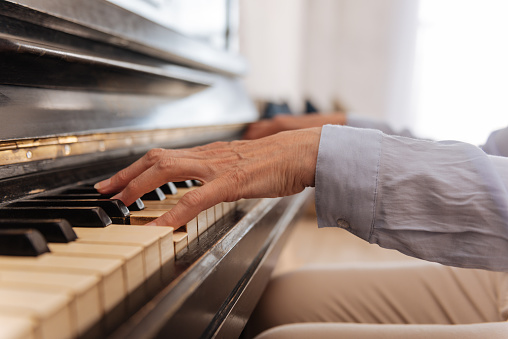 Close up of female hand while playing the piano