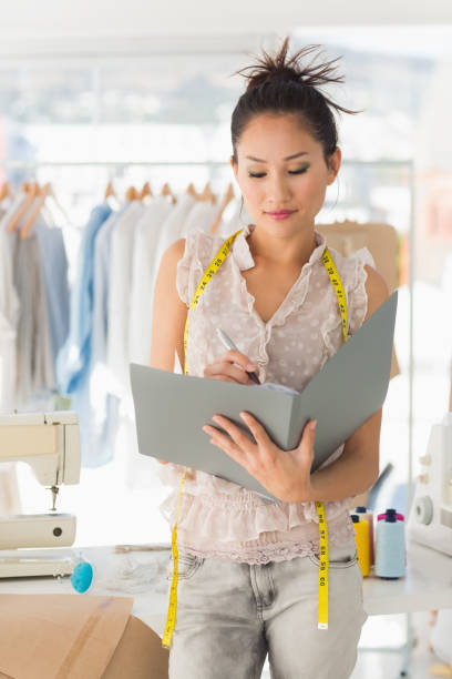 istock Female fashion designer looking at folder 690001232