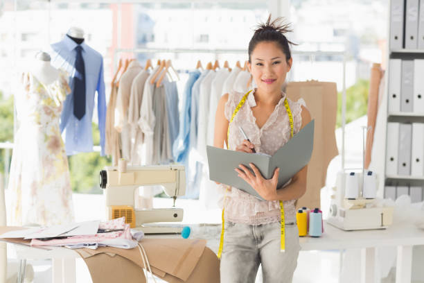 istock Beautiful female fashion designer with folder 690001240