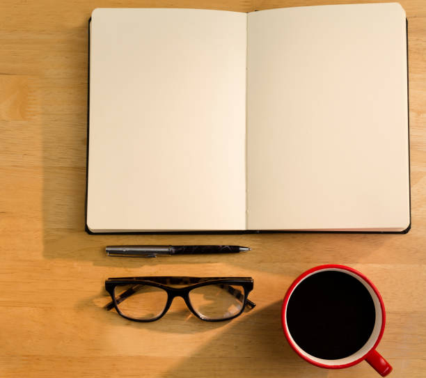istock Overhead of open notebook with pen glasses and coffee 690001340