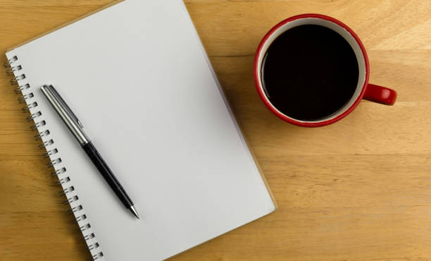 istock Overhead of notebook with pen and coffee 690001414