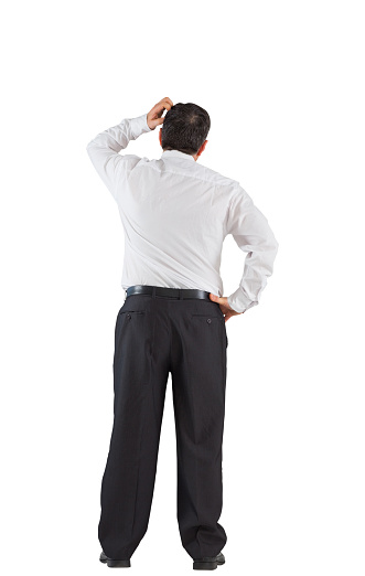 Mature businessman standing scratching head on white background