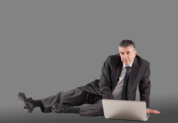 istock Concentrating businessman lying on floor using laptop 690002304