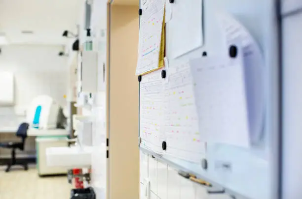 Close-up of bulletin board in laboratory. Test results attached on board over wall. It is in hospital.