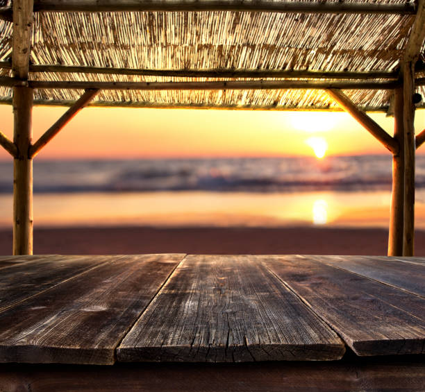 empty bar table at the beach empty bar table against sunset at the beach beach bar stock pictures, royalty-free photos & images