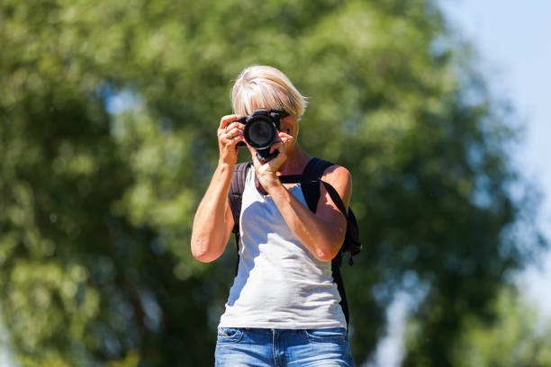 istock mature woman taking photos 690009326