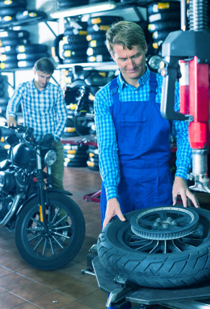 istock mechanic with bike wheel in workshop 690018380