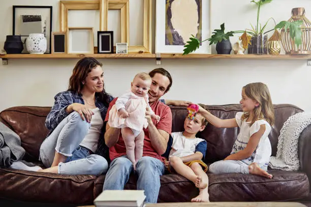 Shot of a happy and loving young family sitting on the sofa at home