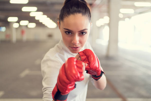 mujer joven en el gimnasio de boxeo - posing looking at camera combative sport boxing fotografías e imágenes de stock