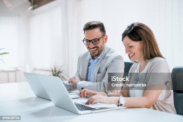 Photo libre de droit de Deux Entrepreneurs Assis Ensemble Travaillant Dans Un Bureau banque d'images et plus d'images libres de droit de Ordinateur portable