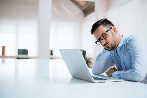 istock Tired student or businessman working with laptop in the office 690028902