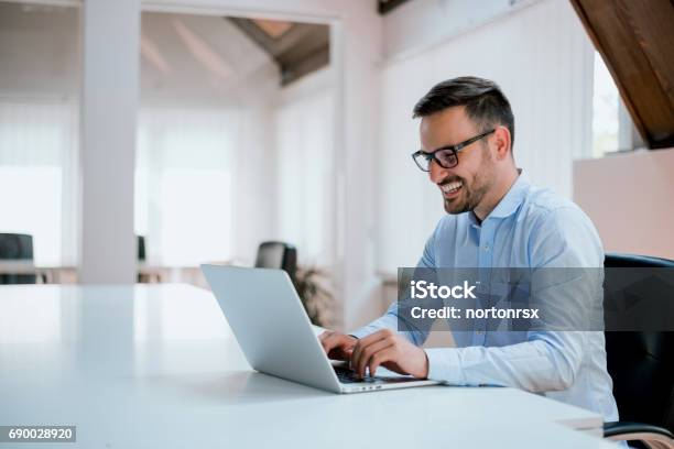 Portrait Of Young Man Sitting At His Desk In The Office Stock Photo - Download Image Now