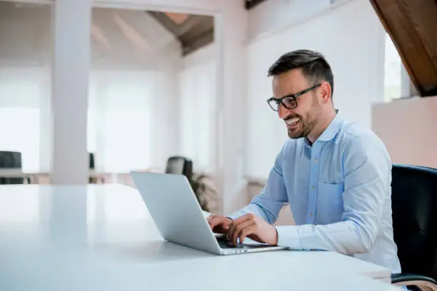 Photo of Portrait of young man sitting at his desk in the office