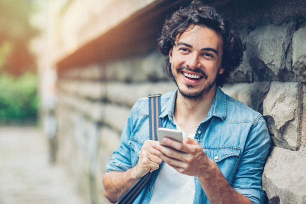 istock Smiling man with smart phone outdoors 690029720