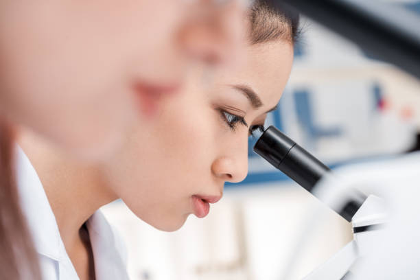 istock asian scientist in lab coat working with microscope in chemical lab 690031966