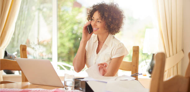 hablando con un cliente feliz - working at home mature adult small business laptop fotografías e imágenes de stock