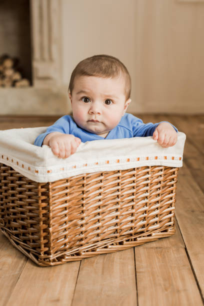 istock baby boy sitting inside of braided box and looking at camera 690032254