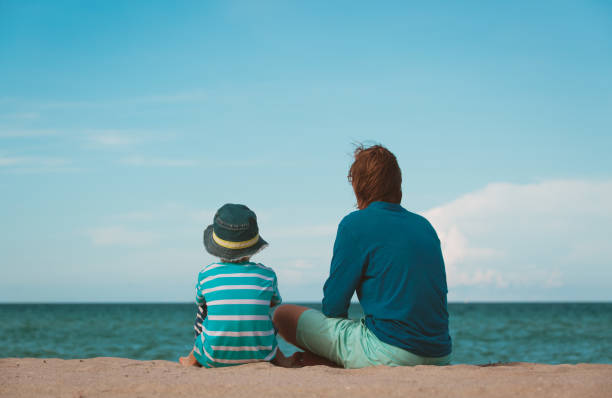 istock father and little son talking on beach 690032532