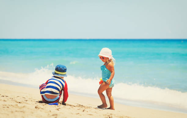 istock kids play with sand on summer beach 690033212