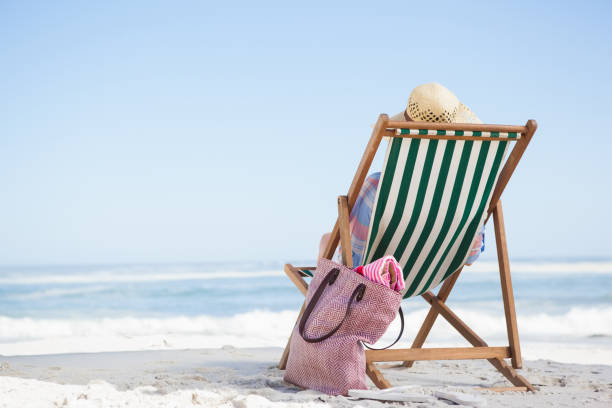 istock Woman sitting on beach in deck chair 690033226