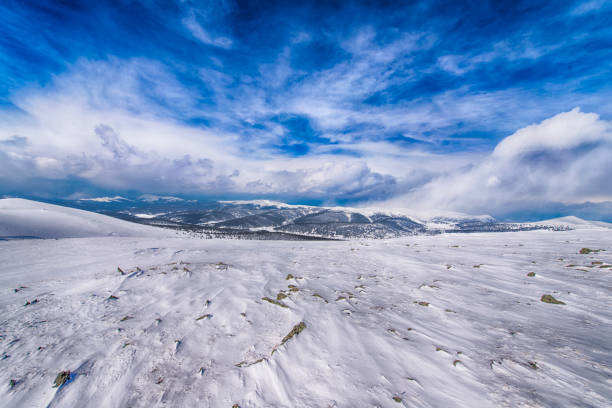The beautiful Carpathian mountains covered with evergreen forests and snow-white snow are sheltered under powerful fluffy clouds