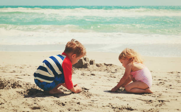 istock kids play with sand on summer beach 690036350