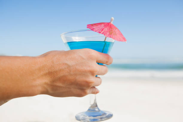 istock Woman sitting in deck chair with a cocktail at the beach 690036708