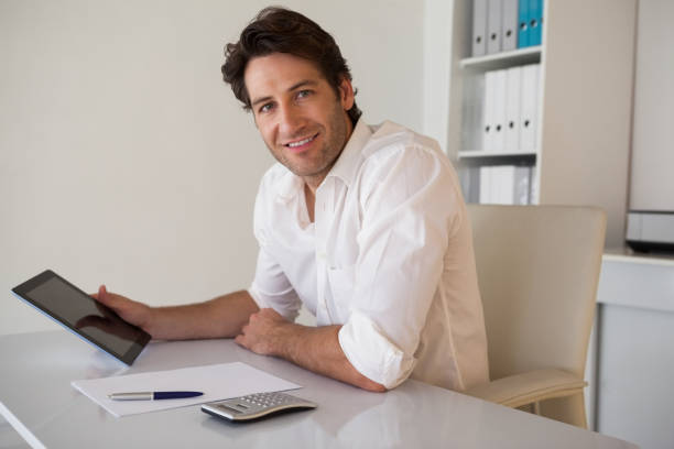 istock Casual smiling businessman using tablet and calculator 690036726