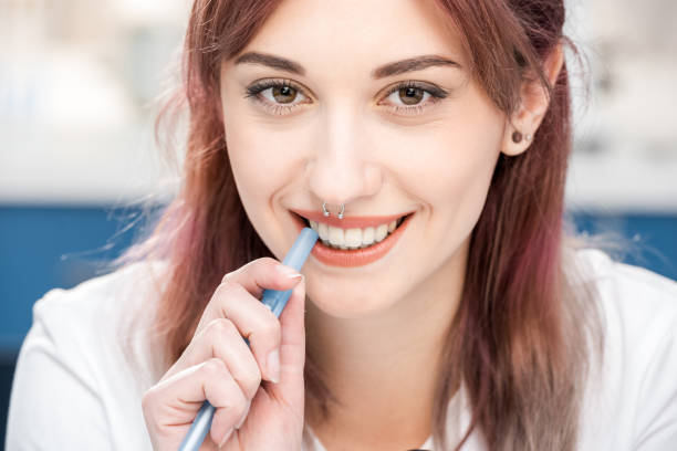 istock young scientist in lab coat with pen looking at camera in chemical lab 690044562